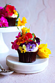Japanese-inspired carrot cupcake with apple mint and edible flowers, close-up.