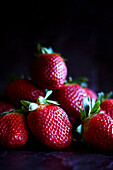 Frische rote Erdbeeren Closeup auf dunklem Hintergrund mit negativem Raum.