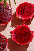 Dragon fruit, also known as pitaya, sliced pink-magenta coloured flesh with tiny black seeds, tropical fruit