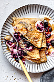 Gluten-free paleo crepes made from almond flour with berry compote and cream