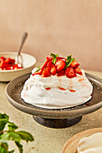 Strawberry and mint pavlova with cream on a grey serving dish