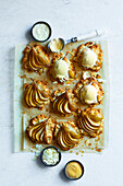 Freshly baked pear and almond cake, on brown baking paper, topped with vanilla ice cream on a white marble base