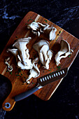 Fresh oyster mushrooms on a chopping board, close-up.