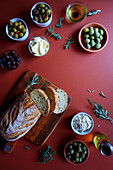 Selection of olive products, including Kalamata olive sourdough bread, green olive dip, olive oil, dairy-free olive spread, Sicilian olives and marinated green and black olives.