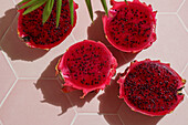 Dragon fruit, also known as pitaya, sliced pink-magenta coloured flesh with tiny black seeds, tropical fruit