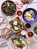 Gesundes Abendessen aus saisonalen Zutaten: Tofu mit Grünkohl, Pizza Florentina mit Grünzeug und Eiern, gedämpfte Zuckerschoten, gebratener Fisch und Sauerteigbrot.
