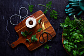 Preparation of homemade bouquet garni with parsley, bay leaves, sage, rosemary and celery leaves.