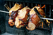 Close-up of juicy pieces of meat being roasted on metal skewers over open flames. Barbecue grill with visible fire on which marinated pieces of meat are roasted.