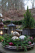 Weihnachtliche Terrassendekoration mit Tannenzweigen, Weihnachtsbaumkugeln und Laternen