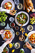 Italienisches Abendessen mit Salat, Pasta, Baguette, Grissini, Oliven und Obst