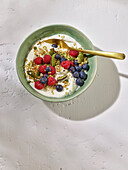Yoghurt with matcha pistachio granola from the pan and berries