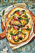Gluten-free tarte flambée with nectarines, peas and bacon