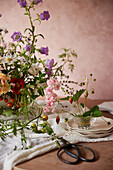 Colourful bouquet of summer flowers and wild strawberries on a wooden table