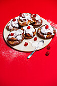 Sweet almond and yeast dough swirl with icing and candied cherries