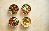 Vier verschiedene Gerichte mit Kichererbsen - Falafel, Za'atar-Kichererbsen-Salat, Curry, Hummus