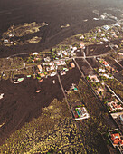 Aerial view of volcanic landscape with buried houses and lava flow, Los Llanos de Aridane, Spain.