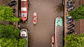 Aerial view of a small boat driving in the canal of Amsterdam, The Netherlands.