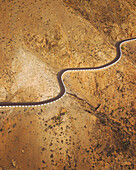 Luftaufnahme einer kurvenreichen Serpentinenstraße durch trockenes Bergland, Betancuria, Fuerteventura, Kanarische Inseln, Spanien.