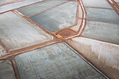 Aerial view of colorful salt evaporation ponds with geometric patterns and reflections, Useless Loop, Australia.