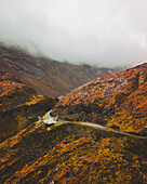 Aerial view of an abstract sculpture along the road on the mountain with fog, Norway.