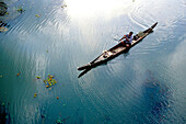 Aerial view of Indian man riding in boat in backwater, Kerala, India