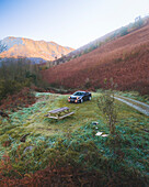 Accous, France - 15 November 2024: Aerial view of a serene and misty morning landscape with a road and car amidst the tranquil mountains and hillside, Accous, France.