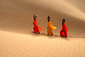 Luftaufnahme von Rajasthani-Frauen mit Krügen auf dem Kopf auf der Sanddüne von Khuri Khurri, Jaisalmer, Rajasthan, Indien