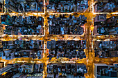 Looking down onto apartment blocks from a drones' perspective within the Kowloon district of Hong Kong at night.