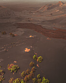 Aerial view of volcanic eruption aftermath with buried houses and scorched earth, El Paso, Spain.