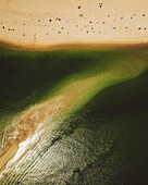 Aerial view of Praia de Figueirinha beach with clear blue water and sandy shoreline, Setubal, Portugal.