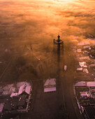 Aerial view of a mystical city shrouded in fog at sunrise with a historic church, Workum, Friesland, Netherlands.