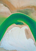 Aerial drone view of a creek running in the Noosa North Shore sandbank at sunset on the Sunshine Coast, in Queensland Australia. The green colour of the water comes from sediments brought in by tides.