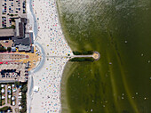 Aerial view of a beautiful sandy beach by the ijsselmeer lake on a sunny summer day with people enjoying relaxation, Makkum, Netherlands.