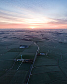 Aerial view of a beautiful farm surrounded by fields and fog at sunrise, Piaam, Netherlands.