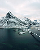 Aerial view of iconic Fredvang Bridges and snowy mountains, Lofoten Islands, Northern Norway in the Arctic Circle