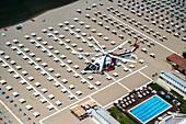 Tuscany, Italy - 16 July 2018: Aerial view of an AW 139 Agusta helicopter of the Italian Coast Guard flying over the beaches of Versilia during surveillance from above, Tuscany, Italy.