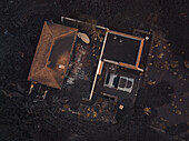 Aerial view of a building covered with ashes from Cumbre Vieja volcano in La Palma island, Canary Islands, Spain.