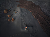 Aerial view of a building covered with ashes from Cumbre Vieja volcano in La Palma island, Canary Islands, Spain.