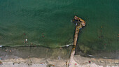 Aerial view of beach with pier, ocean waves, and people enjoying the sunny day, Santa Marta, Colombia.