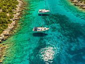 Luftaufnahme von zwei Booten, die zwischen Inseln vor Anker liegen, Ithaki, Griechenland.