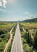 Aerial view of the empty asphalt road in the countryside with the mountains on the horizon