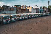 Gurugram, India - 16 April 2020: Aerial view of a line of public buses parked in a parking lot in Gurugram during lockdown, Haryana state, India.