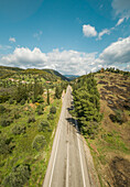 Aerial view of asphalt road in the countryside with the mountains on the horizon