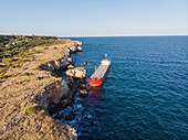 Aerial view of stranded ship Vera Su near rugged cliffs and tranquil sea, Kamen bryag, Bulgaria.