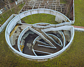 Aerial view of spiral concrete structure with circular stairs and green grass, Camoes Car Park, Guimaraes, Portugal.