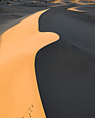 Luftaufnahme von schönen Sanddünen bei Sonnenuntergang mit Schatten und Fußabdrücken, Stovepipe Wells, Vereinigte Staaten.