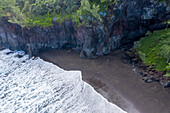 Aerial view of a person standing at Black Sand Beach near Saint Joseph town, Reunion Island.