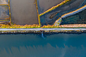 Aerial view of the patterns and colors of salt evaporation ponds during sunrise time in Aveiro, Portugal