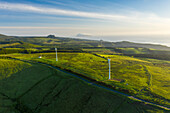 Aerial view of wind turbines in countryside at sunset on Ilha das Flores, Azores islands, Portugal.