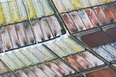 Aerial view of the patterns and colors of salt evaporation ponds during sunrise time in Aveiro, Portugal